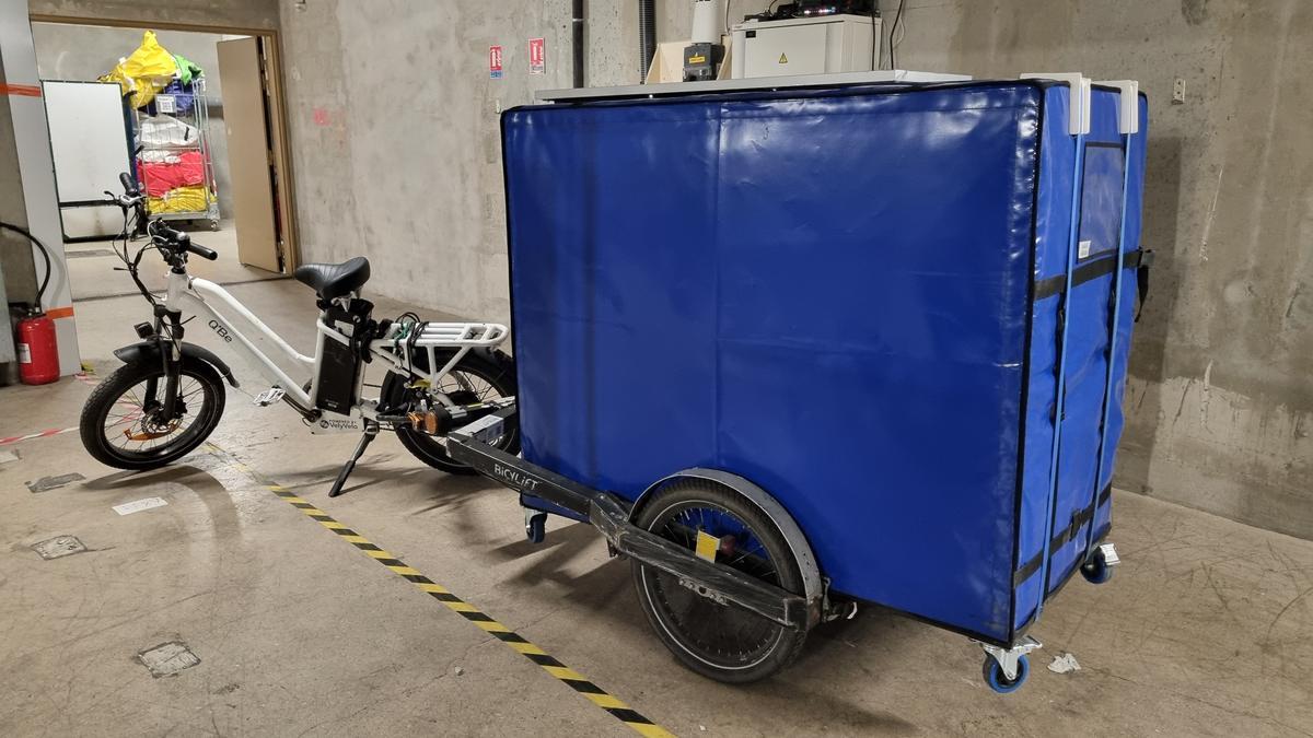 Conteneur isotherme posé sur son châssis à roulettes, monté sur la remorque.